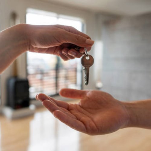 Close-up on a real estate agent giving the keys of his new house to a man - home ownership concepts